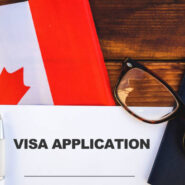Flag of Canada, visa application form and passport on table